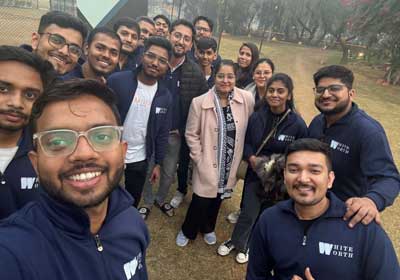 Team members in WhiteWorth jackets taking a group selfie outdoors on a winter morning