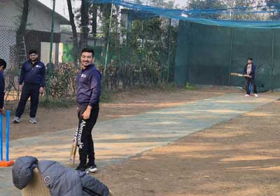 Team members playing cricket at the practice nets