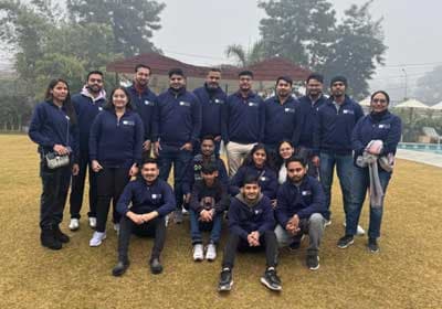 Group photograph of the WhiteWorth team in matching jackets on the lawn